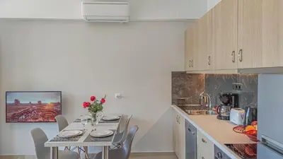 a kitchen with a table and chairs in a kitchen at Fully renovated apartment in Platanias 1 in Plataniás