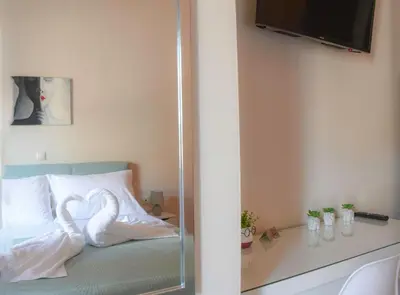 a bedroom with a bed with white sheets and a mirror at Giovanni City House near Chania City Center in Chania Town