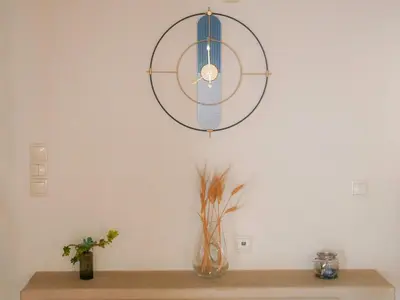a clock on a wall with a vase on a table at Giovanni City House near Chania City Center in Chania Town