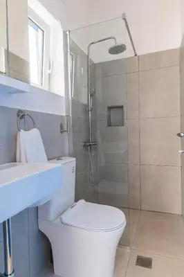 a bathroom with a shower and a toilet and a sink at Babis & Popi Rooms and Studios in Frangokastello
