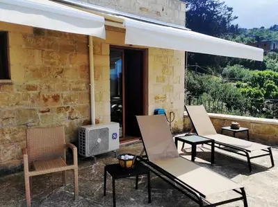 a group of chairs and an umbrella on a patio at VILLA IRIS in Vryses