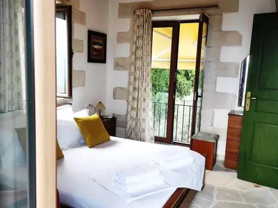a bedroom with a bed and a large window at VILLA IRIS in Vryses