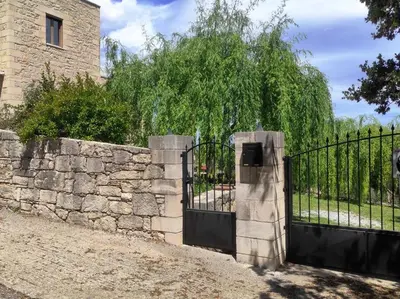 a stone fence with a gate and a stone wall at VILLA IRIS in Vryses