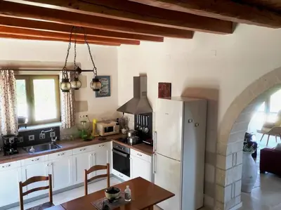 a kitchen with a white refrigerator and a table at VILLA IRIS in Vryses