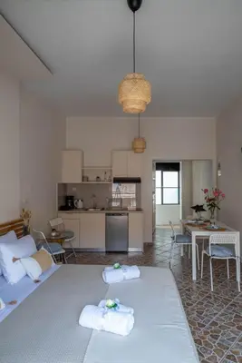 a living room with a couch and a table and a kitchen at Four Seasons in Chania Town