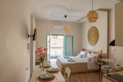 a living room with a bed and a table with flowers at Four Seasons in Chania Town