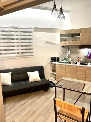 a living room with a black couch and a kitchen at Lux and modern apartment Chania in Chania Town