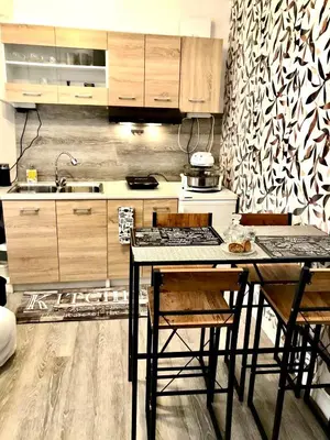 a kitchen with wooden cabinets and a table with chairs at Lux and modern apartment Chania in Chania Town
