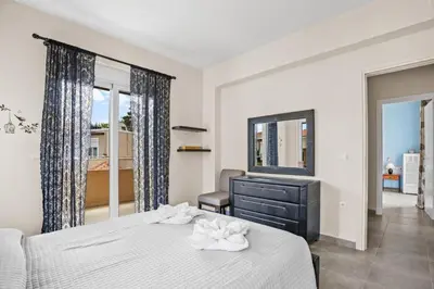 a bedroom with a bed and a dresser and a mirror at Villa Blue Dreams in Maleme in Ayiá