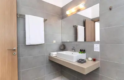 a bathroom with a white sink and a mirror at Villa Vereniki in Áyios Andhréas
