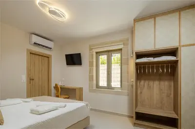a white bedroom with a bed and a window at ALKI VILLAS COLLECTION -LUXURY SEA VIEW VILLAS - BREAKFAST INCLUDED- Falasarna in Falasarna