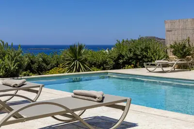 a swimming pool with two lounge chairs next to it at ALKI VILLAS COLLECTION -LUXURY SEA VIEW VILLAS - BREAKFAST INCLUDED- Falasarna in Falasarna