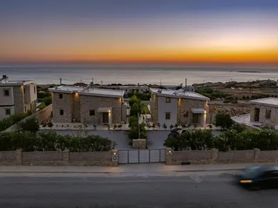 a villa with a view of the ocean at sunset at ALKI VILLAS COLLECTION -LUXURY SEA VIEW VILLAS - BREAKFAST INCLUDED- Falasarna in Falasarna