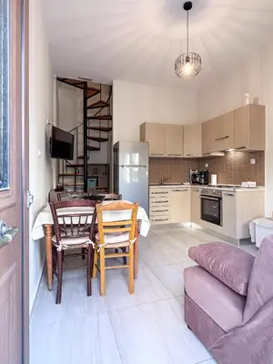 a kitchen and living room with a table and chairs at KOSTAS HOUSE in Chania Town