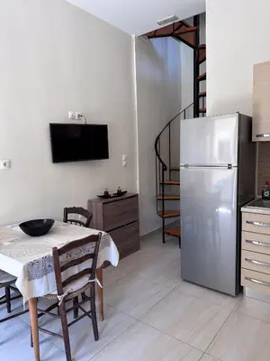 a kitchen with a table and a stainless steel refrigerator at KOSTAS HOUSE in Chania Town