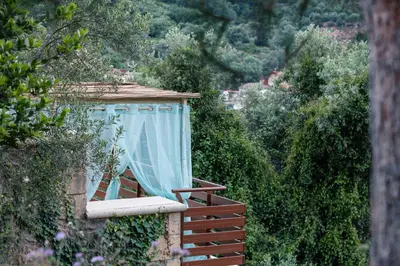 a window with a blue curtain on a balcony at Kotinos Luxury Villa in Chania Town