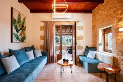 a living room with blue couches and a table at Kotinos Luxury Villa in Chania Town