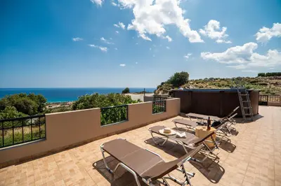 a patio with chairs and a view of the ocean at Serenitas, family house with great views in Sfakiá