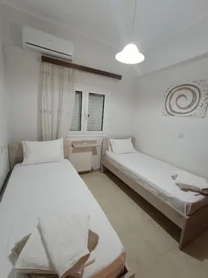 two beds in a room with white walls at Serenitas, family house with great views in Sfakiá