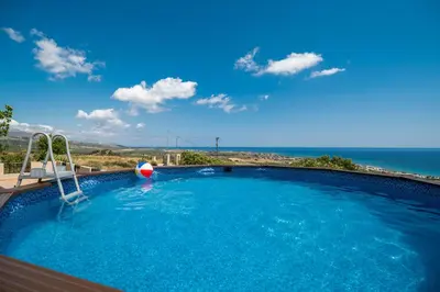 a large swimming pool with a view of the ocean at Serenitas, family house with great views in Sfakiá