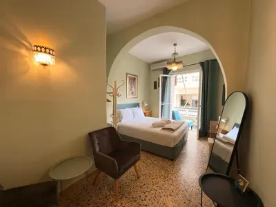 a bedroom with a bed and a chair and a mirror at Omiros Apartment in Chania Town
