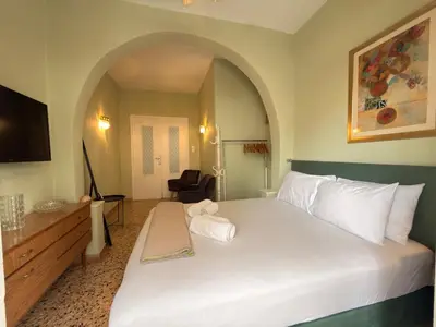 a bedroom with a large white bed and a tv at Omiros Apartment in Chania Town
