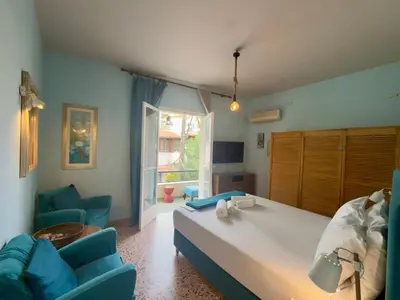 a bedroom with a bed and two blue chairs at Omiros Apartment in Chania Town