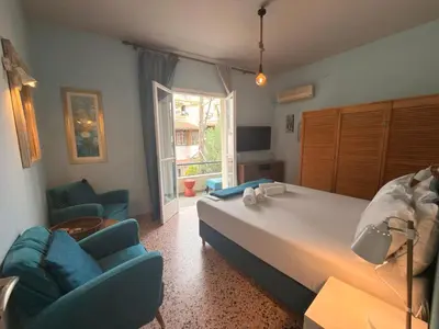 a bedroom with a large bed and two chairs at Omiros Apartment in Chania Town