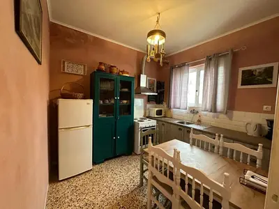 a kitchen with a green cabinet and a white refrigerator at Omiros Apartment in Chania Town