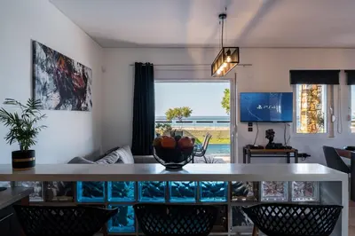 a living room with a table and chairs at Villa Per Mare in Maleme