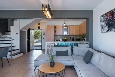 a living room with a couch and a table at Villa Per Mare in Maleme