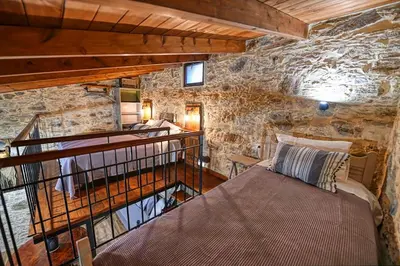 a bedroom with a bed in a stone wall at PefkoPetro Loft in Chania Town
