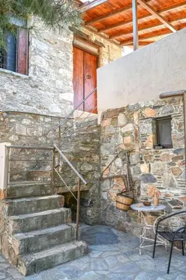 a stone building with stairs and a table and a door at PefkoPetro Loft in Chania Town