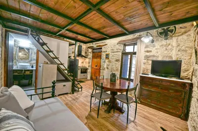 a living room with a table with chairs and a kitchen at PefkoPetro Loft in Chania Town