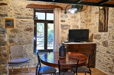a dining room with a table and a television at PefkoPetro Loft in Chania Town