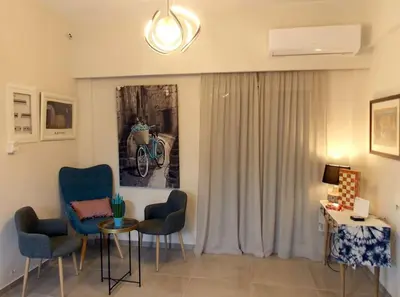a living room with chairs and a table and a window at Alena home in Chania Town