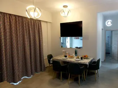 a dining room with a table and chairs and a television at Alena home in Chania Town