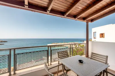 a balcony with a table and chairs and the ocean at Superb apartmentS Kriaras sea view in Sfakia in Khóra Sfakíon