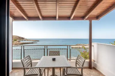 a table and chairs on a balcony with a view of the ocean at Superb apartmentS Kriaras sea view in Sfakia in Khóra Sfakíon
