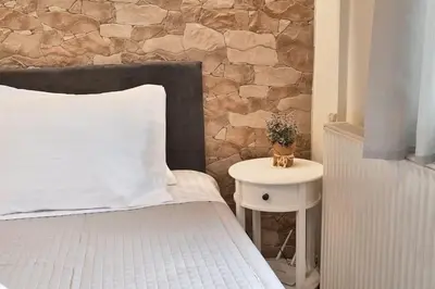 a bed with a white pillow and a side table at Lux and Cozy in Kato Daratso