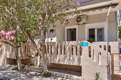 a white fence in front of a house with trees at Lux and Cozy in Kato Daratso