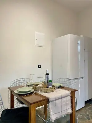 a kitchen with a table with plates and a refrigerator at almond home in Livadia