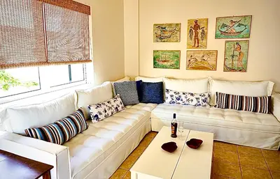 a living room with a white couch and a table at Atreas’ Art Studio in Chania Town