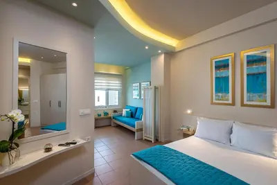 a bedroom with a bed and a living room at Studios Rika in Plataniás