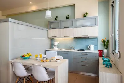 a kitchen with a table and chairs in a room at Studios Rika in Plataniás