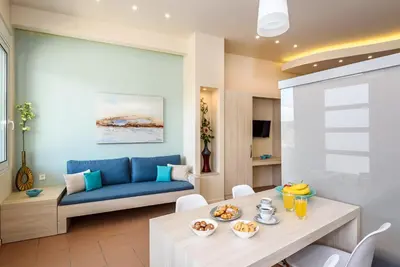 a living room with a table and a blue couch at Studios Rika in Plataniás