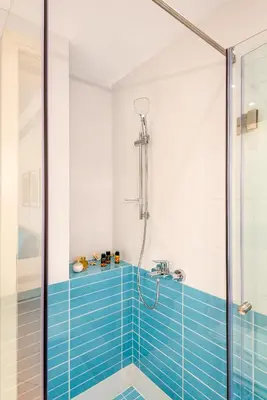 a bathroom with a shower with blue tile at Studios Rika in Plataniás
