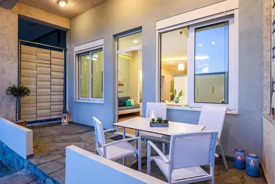 a table and chairs on a patio with a window at Studios Rika in Plataniás