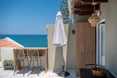 a patio with a table and chairs and an umbrella at Lavender suite sea view in Plataniás