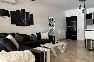 a living room with a black couch and a table at Anna Kavros luxury apartment in Chania Town